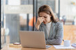 © ArLawKa - Stressed and frustrated asian female accountant sitting at desk making serious business decisions Worried about the project she's working on and the pain in her eyes looking at the screen?