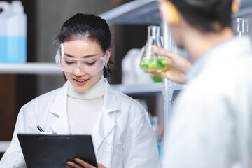 Wall Mural - Pharmaceutical factory woman worker in protective clothing operating production line in sterile environment, scientist with glasses and gloves checking hemp plants in a marijuana farm