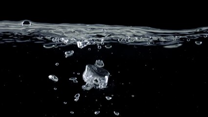 Wall Mural - Surface of water on black background, air bubbles rise up. Slow motion shot of boiling water