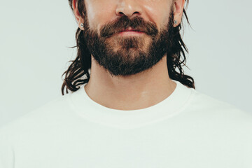 Wall Mural - Man with a beard and perfect skin standing in a studio