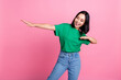 Photo of pleasant optimistic girl with bob hairdo wear green t-shirt look empty space dancing have fun isolated on pink color background