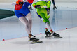 back two male skaters run together warm-up speed skating competition, winter sports games