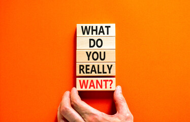 Wall Mural - What do you really want symbol. Concept words What do you really want on wooden block. Beautiful orange table orange background. Businessman hand. Business what do you really want concept. Copy space.