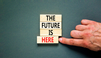Wall Mural - The future is here symbol. Concept words The future is here on wooden block. Beautiful grey table grey background. Businessman hand. Motivational business the future is here concept. Copy space.