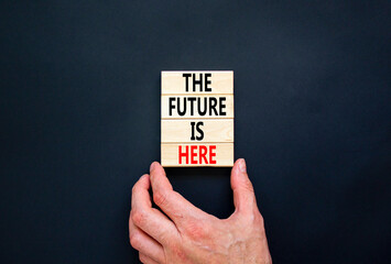 Wall Mural - The future is here symbol. Concept words The future is here on wooden block. Beautiful black table black background. Businessman hand. Motivational business the future is here concept. Copy space.