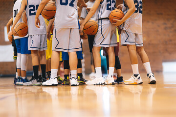 Wall Mural - Junior Basketball Team During Training Class Standing Together and Huddling in Circle. Players Listening to Coaches' Motivational Speech Before The Game. Men's College Basketball Team at Tournament