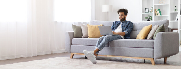 Remote Work. Smiling Indian Freelancer Guy Working With Laptop At Home