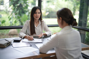 Wall Mural - Confident young asian business woman working on laptop. Creative female executives meeting in modern startup office.