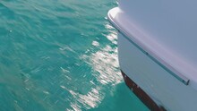 Close Up Of The Bow Of A Recreational Power Boat Cutting Through The Water. Boat Bow Cutting The Ocean Water With Water Splashes. Boat Cutting Through The Waves. Concept Of Sea Travel On A Yacht.