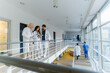 © Maskot - Female doctor discussing with colleagues in corridor at hospital