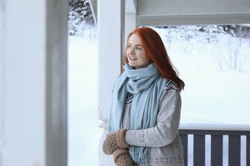 Wall Mural - Beautiful young woman in wooden gazebo on snowy day outdoors. Winter vacation