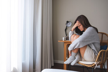 Wall Mural - A young woman feeling sad and stressed, sick and headache at home