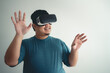 © StockerThings - Asian man enjoy using VR headset for virtual reality access to online data network with laptop.
