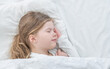 © Ermolaev Alexandr - Smiling little girl sleeps on the bed at home. Top down view. Empty space for text