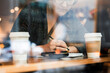 © Astrakan Images - Young woman in cafeteria writing in notebook