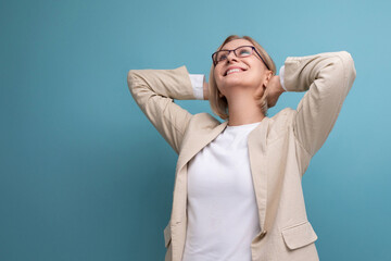 Wall Mural - a middle-aged woman with a bob hairstyle in a classic jacket smiles dreamily while standing against a bright background with copy space