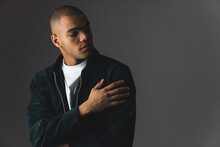 Young African American Man With Buzz Cut On A Dark Studio Background With Dimmed Lights. High Quality Photo