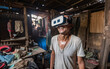 © perfectlab - Happy man in virtual reality glasses in the slums and mess, escape from reality, virtual life concept. Generative AI
