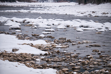 Fototapete - Stones with snow caps in the water of Altai Biya river in winter season.