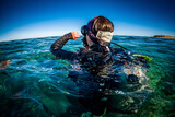 Fototapeta Do akwarium - Scuba Diver Checks Dive Computer on Ocean Surface