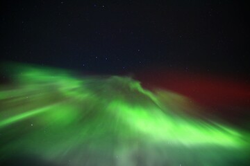 Wall Mural - Red and green aurora formation on starry sky