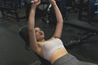 © Mdv Edwards - A young asian lady does a set of incline dumbbell presses. Training chest at the gym.