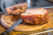 Real hearty homemade roast pork is cut into portions on a wooden board in the kitchen, Germany
