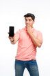 © Niks Ads - Young man standing in casual t shirt and showing smartphone screen.