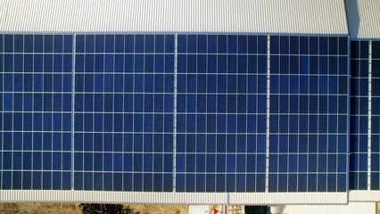 Wall Mural - Aerial drone view of multiple solar panels on the roof of a manufacturing building. Ecology thematics