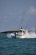Speeding center console fishing boat throwing spray.