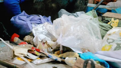 Wall Mural - Employee working with garbage moving on a conveyor belt at waste sorting plant