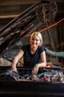 © Austockphoto - young female australian tradesperson mechanic working on car engine in auto repair garage