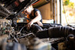 © Austockphoto - tradesperson mechanic working on car engine in auto repair garage