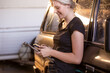 © Austockphoto - Caucasian woman leaning on a classic SUV holding a wrench and a mobile phone
