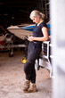 © Austockphoto - Young female aussie mechanic holding tools and leaning on a car in need of repair in workshop garage