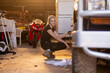 © Austockphoto - Caucasian repairwoman working on fixing a car tyre in garage workshop