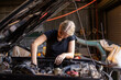 © Austockphoto - young female australian tradesperson mechanic working on car engine in auto repair garage