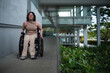 © Austockphoto - smiling woman with a disability in a wheelchair going down ramp
