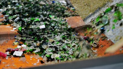 Wall Mural - Process of sorting glass garbage on a vibrating conveyor belt at waste sorting plant. Slow motion