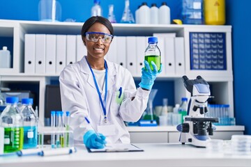 Sticker - Young african american woman scientist measuring liquid at laboratory