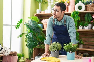 Young hispanic man florist smiling confident standing at flower shop