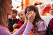 © Krakenimages.com - Woman and group of kids wearing costume applying halloween make up at home