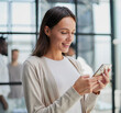 © Katsiaryna - Businesswoman with phone in modern office