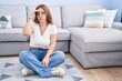 © Krakenimages.com - Young caucasian woman sitting on the floor at the living room worried and stressed about a problem with hand on forehead, nervous and anxious for crisis
