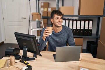 Poster - Young hispanic man ecommerce business worker using laptop drinking coffee at office