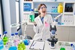 © Krakenimages.com - Young brunette woman working at scientist laboratory celebrating achievement with happy smile and winner expression with raised hand