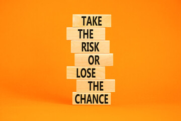 Wall Mural - Risk or chance symbol. Concept words Take the risk or lose the chance on wooden blocks. Beautiful orange table orange background. Copy space. Motivational business risk or chance concept.