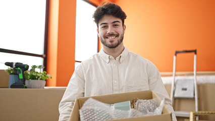 Poster - Young hispanic man smiling confident holding package at new home