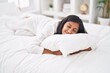 © Krakenimages.com - Young beautiful hispanic woman hugging pillow lying on bed at bedroom
