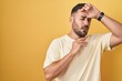 © Krakenimages.com - Handsome hispanic man standing over yellow background touching forehead for illness and fever, flu and cold, virus sick